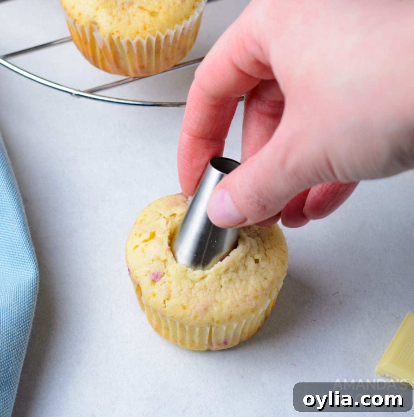 using a piping tip to make a hole in a cupcake