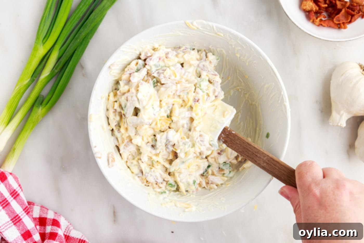Mixing million dollar dip ingredients in a bowl to combine