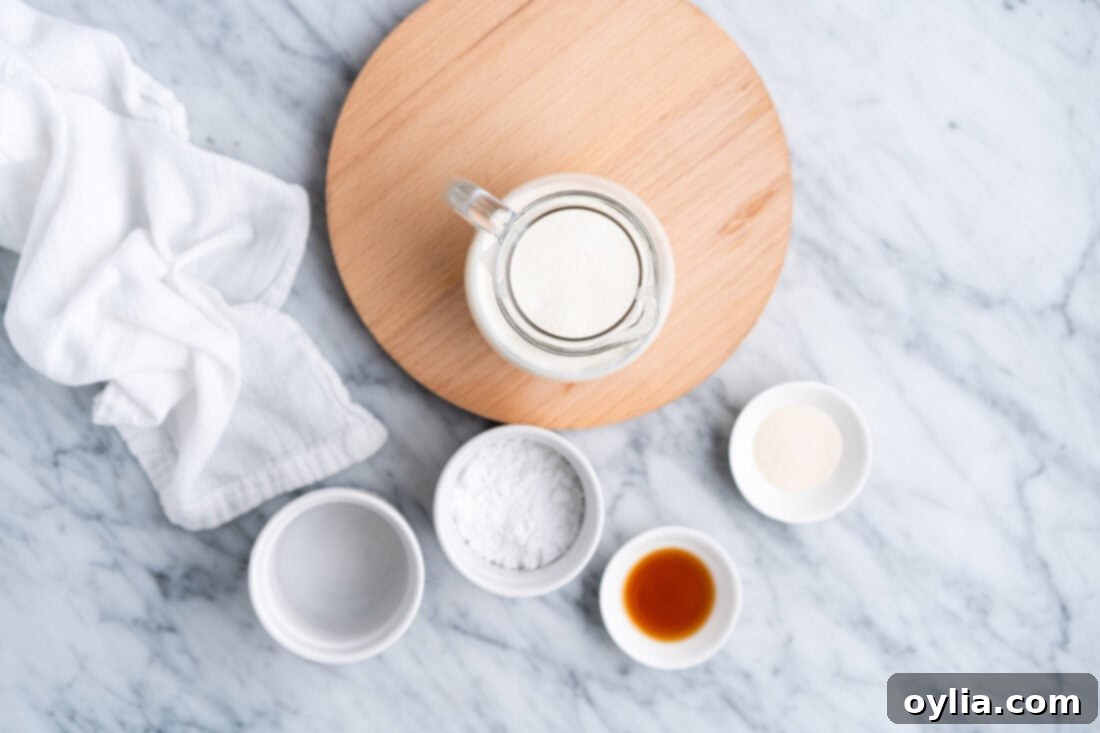 Ingredients for Stabilized Whipped Cream laid out: heavy cream, gelatin, powdered sugar, vanilla, and cold water