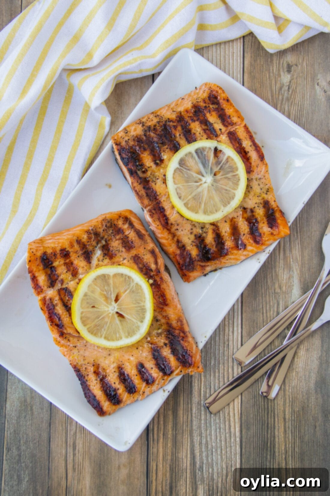 Two perfectly cooked lemon salmon fillets arranged attractively on a platter, ready to be served.