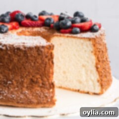 Heavenly Homemade Angel Food Cake 15 Angel Food Cake with a slice removed and topped with berries