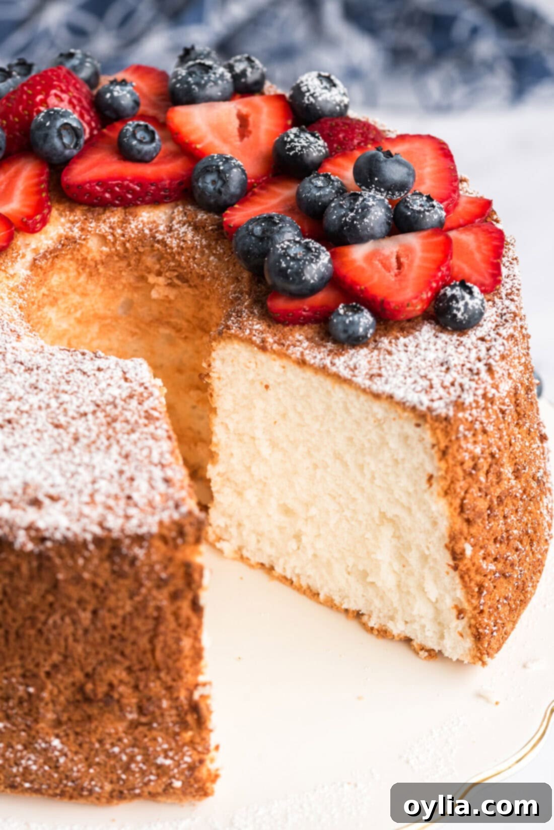 Heavenly Homemade Angel Food Cake 3 Whole Angel Food Cake topped with powdered sugar and berries with one slice removed