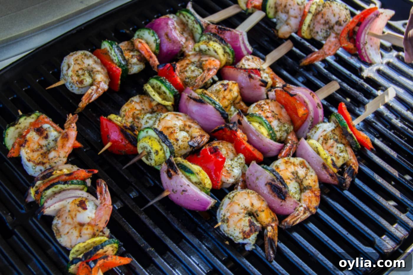 Perfectly cooked shrimp kabobs with charred vegetables resting on the grill.