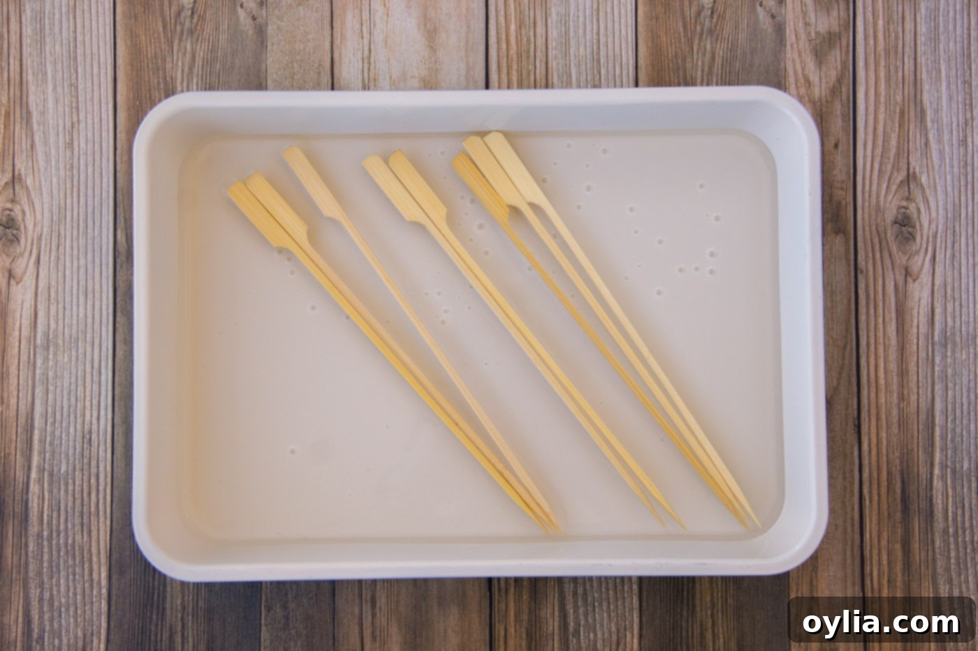 Wooden skewers soaking in water to prevent burning on the grill.