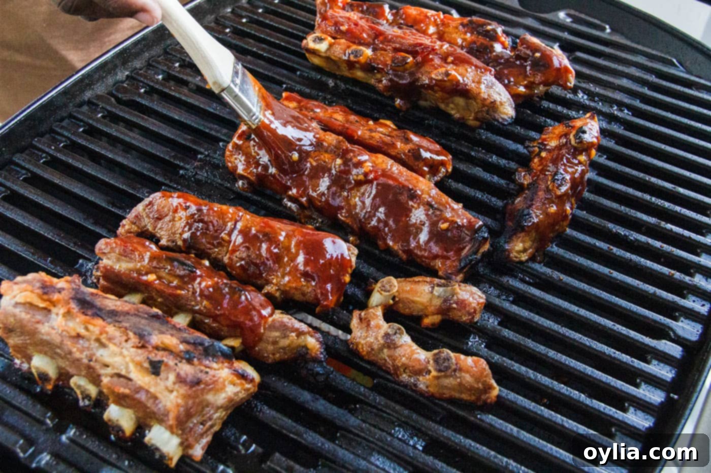 brushing rib tips with barbecue sauce