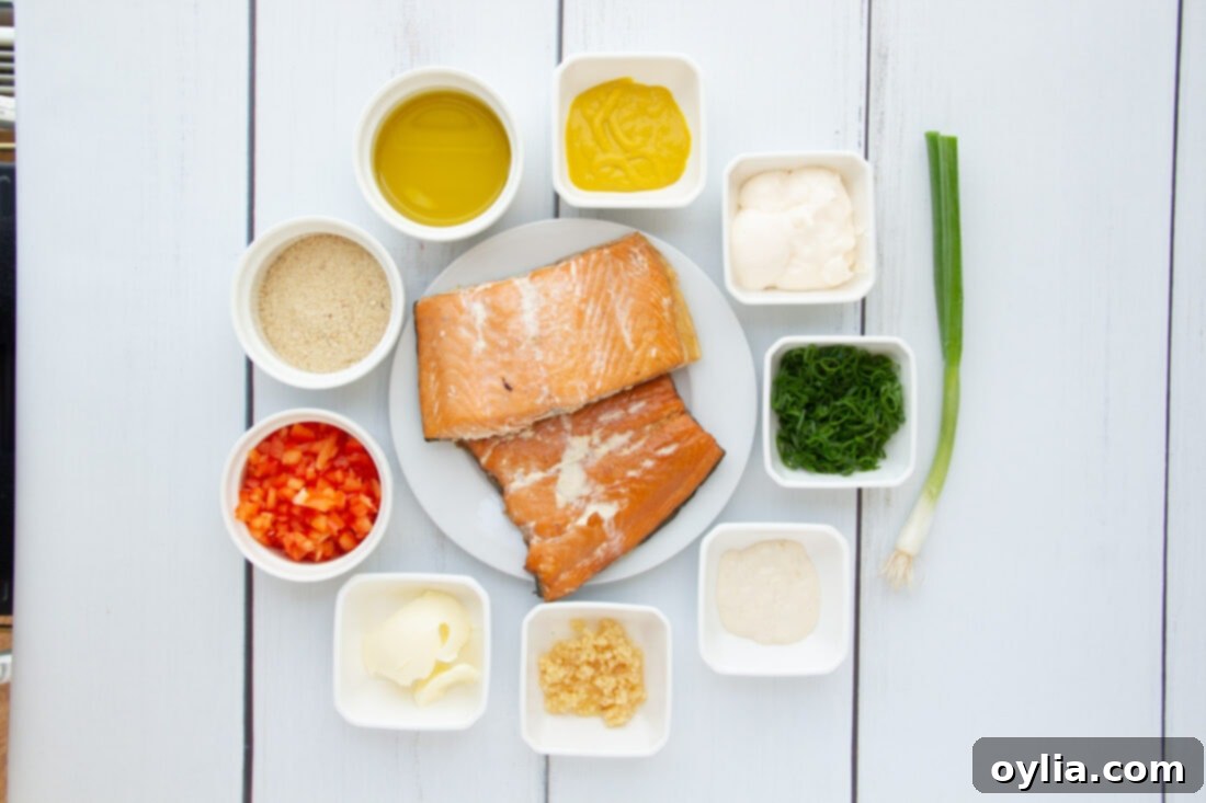 All the raw ingredients for fish cakes, including smoked salmon, bell peppers, garlic, green onions, and various sauces, laid out on a table.