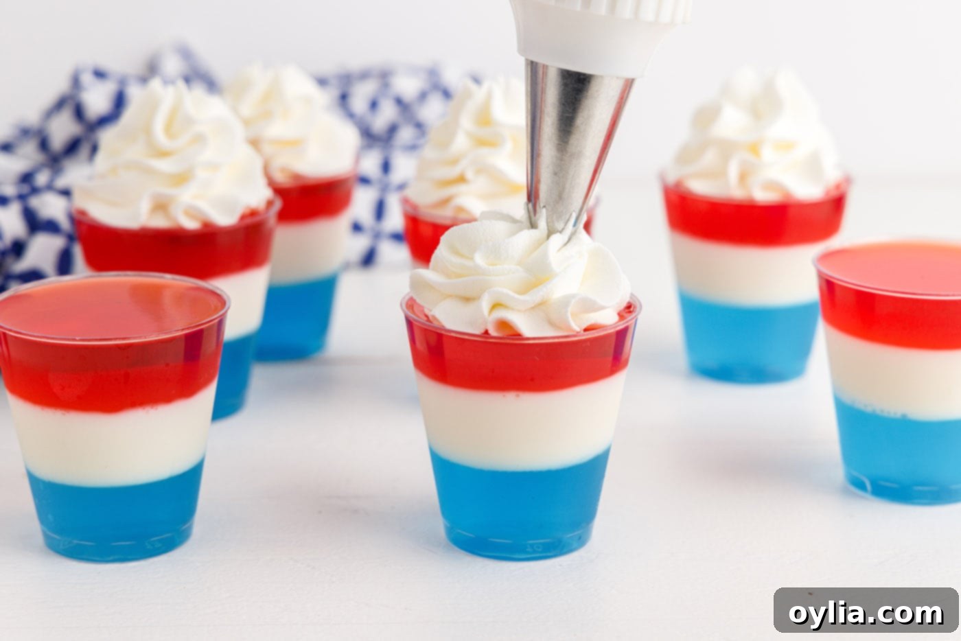 Completed 4th of July Jello Shots with whipped cream and patriotic sprinkles, ready to serve