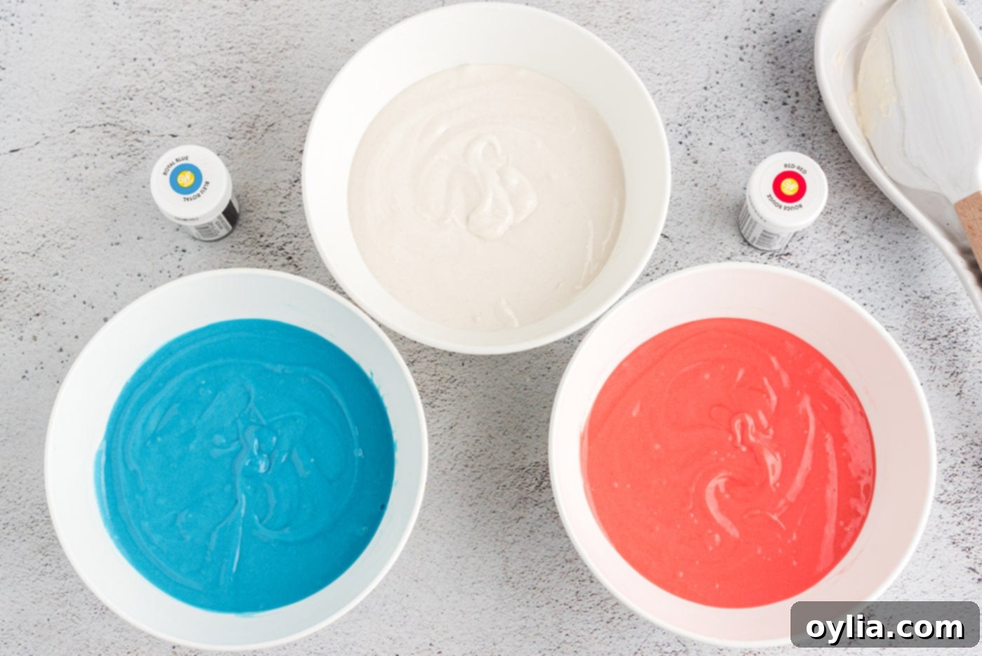 colored cake batter in bowls - red, white, and blue