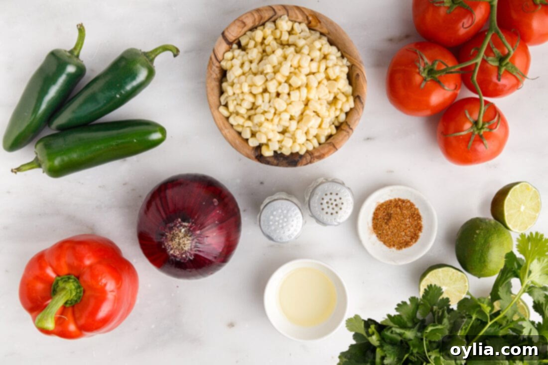 All the fresh ingredients laid out on a cutting board, ready for making corn salsa: corn on the cob, tomatoes, red onion, jalapenos, bell peppers, cilantro, and limes.