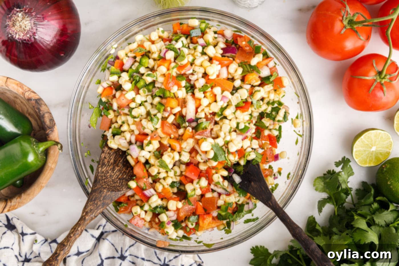 The fully mixed corn salsa, glistening with dressing, presented beautifully in a large serving bowl.