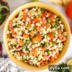 A vibrant bowl of fresh corn salsa with a perfect blend of yellow corn, red tomatoes, and green cilantro, ready to be served.