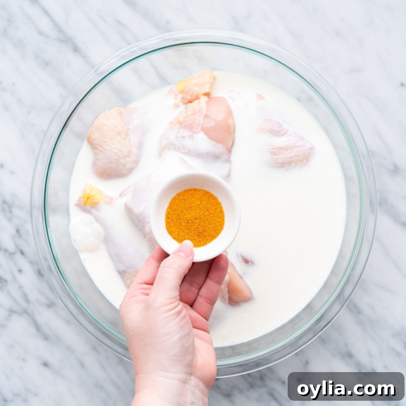 buttermilk and seasoning in a bowl of chicken