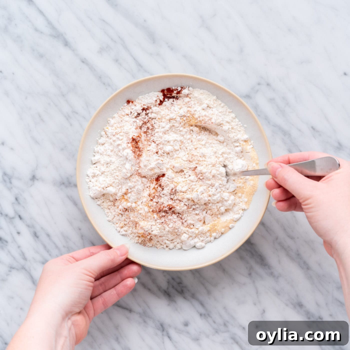 mixing seasoned flour in a shallow bowl