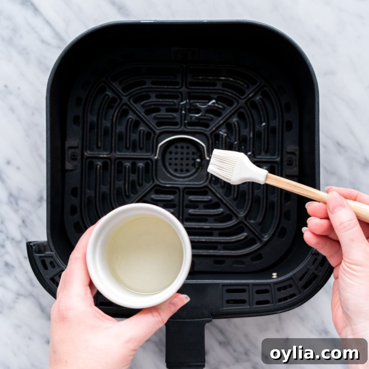brushing air fryer with oil