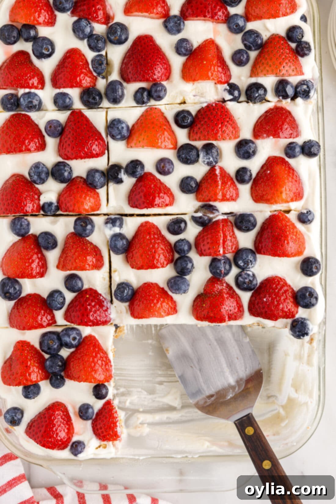overhead of Mixed Berry Icebox Cake with slices removed and spatula in pan