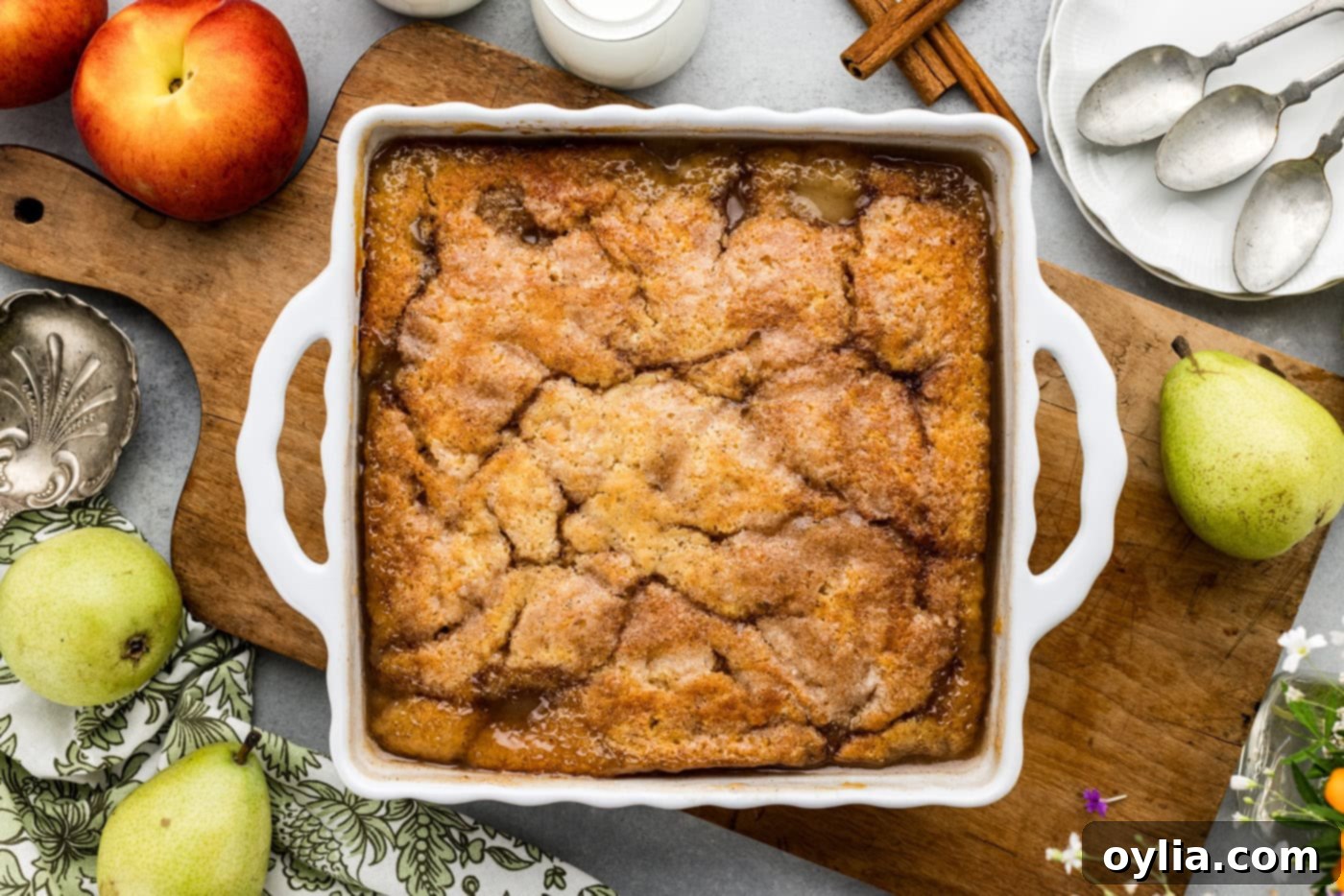 Overhead view of a perfectly baked pear peach cobbler, boasting a golden-brown crust and bubbling fruit filling, fresh out of the oven.