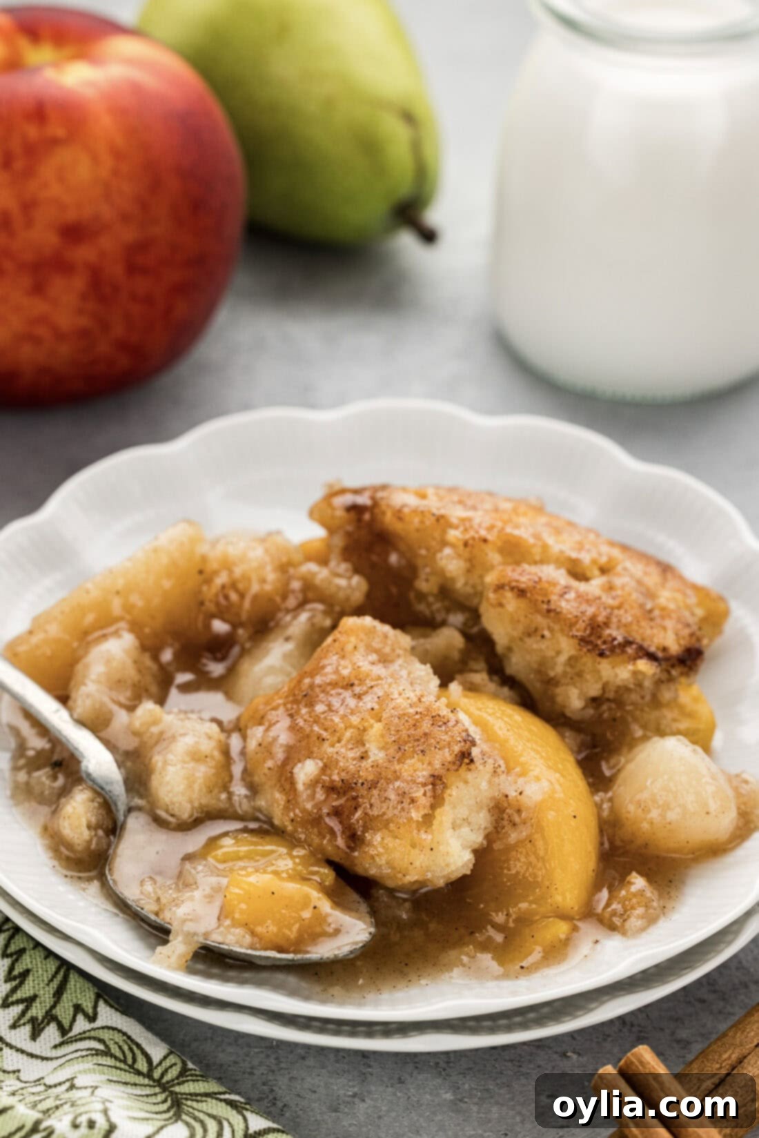 A perfectly portioned plate of warm Pear-Peach Cobbler, showcasing the rich fruit filling and golden crust, ready to be enjoyed.