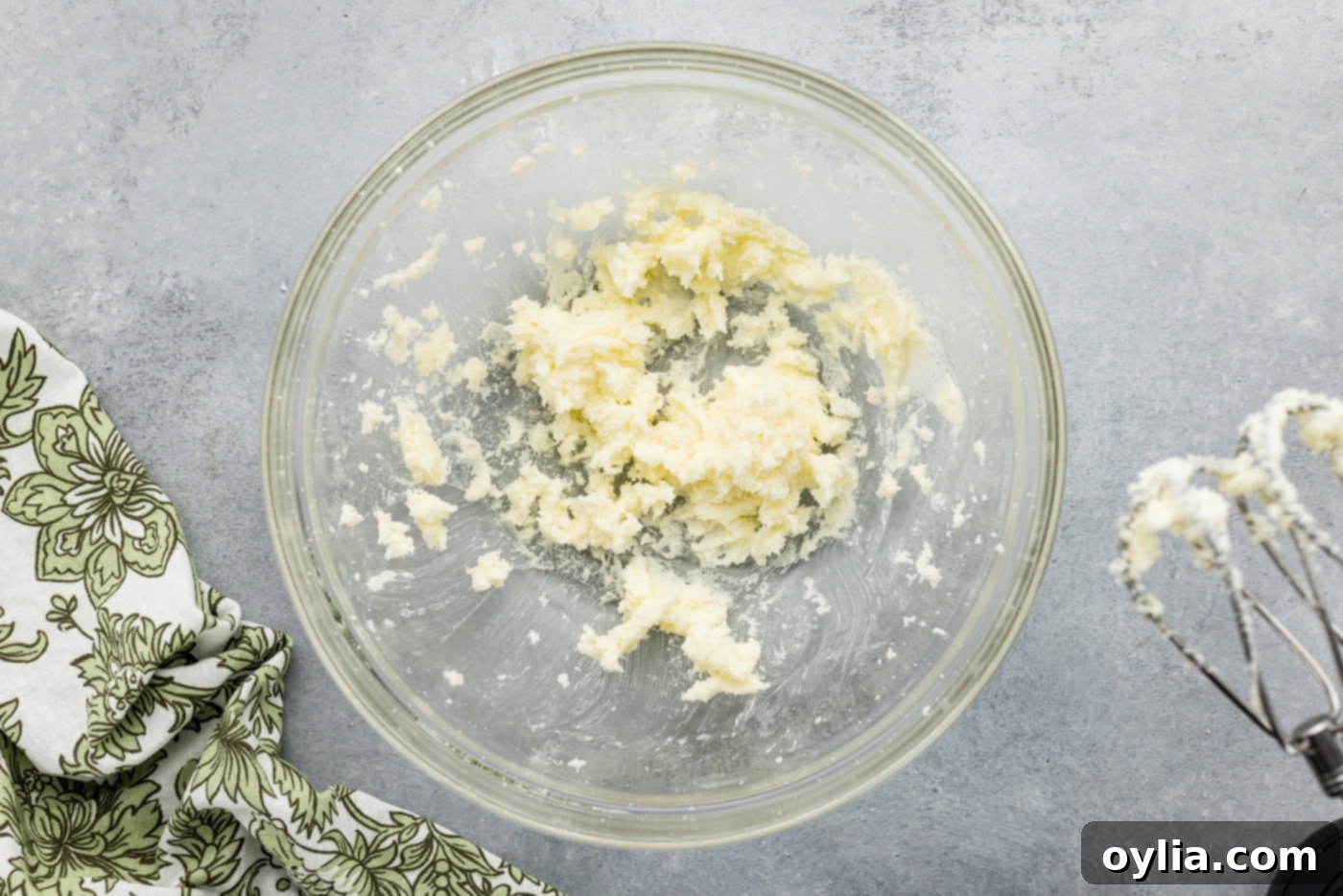 Softened butter and granulated sugar being creamed together in a stand mixer, creating a light, airy, and pale mixture.