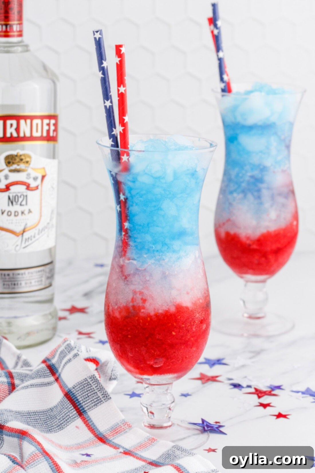Two glasses of Patriotic Vodka Lemonade Slushie, layered in red, white, and blue