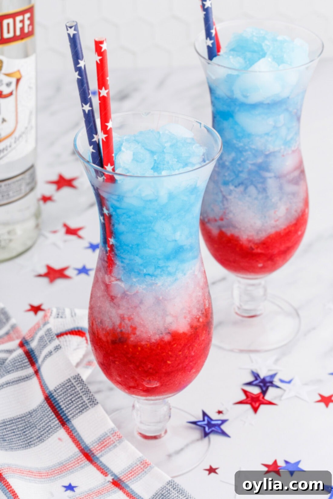 Patriotic Vodka Lemonade Slushies garnished with straws and fresh fruit