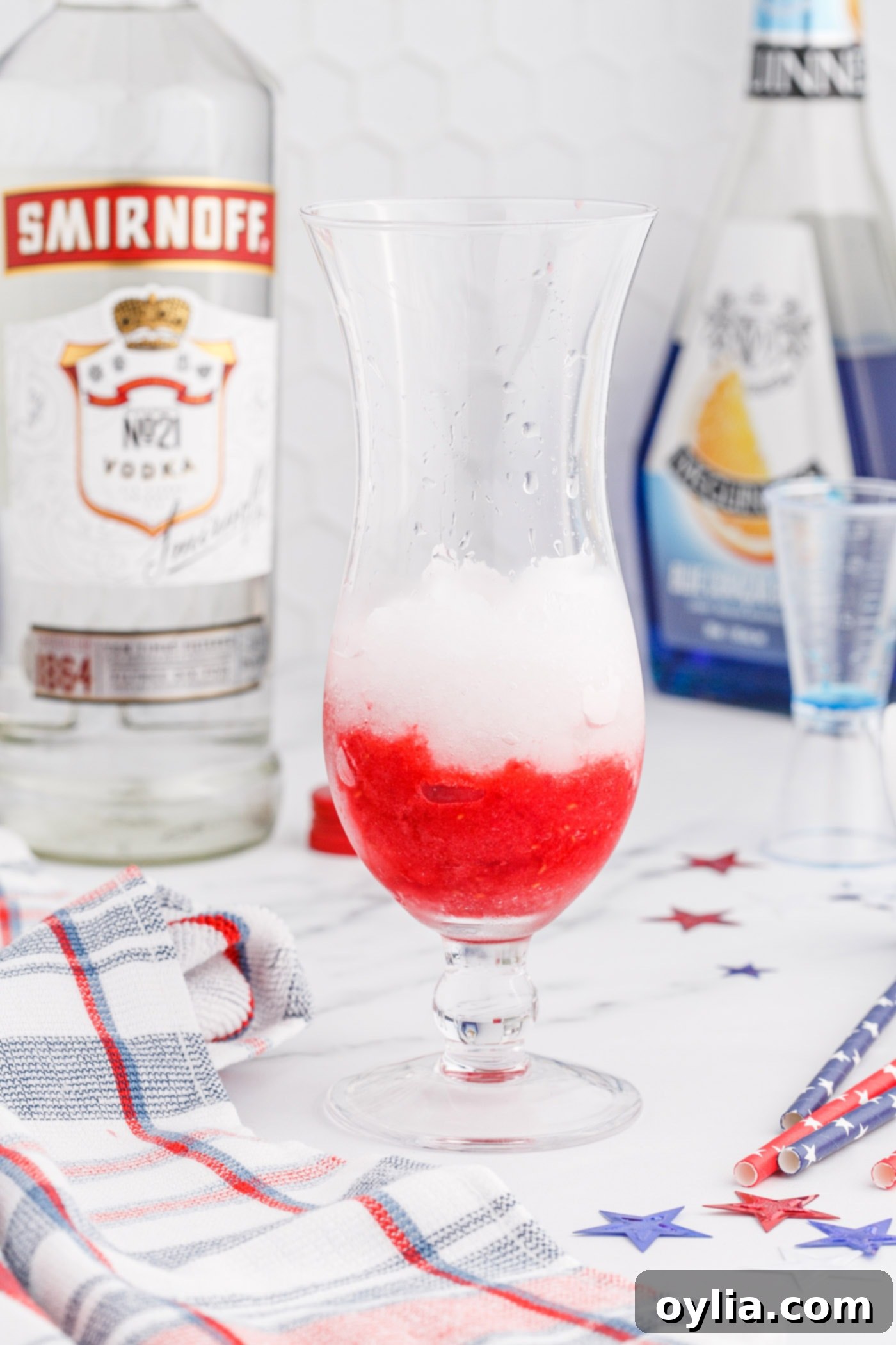 Layering raspberry slush with lemonade slush on top in a glass