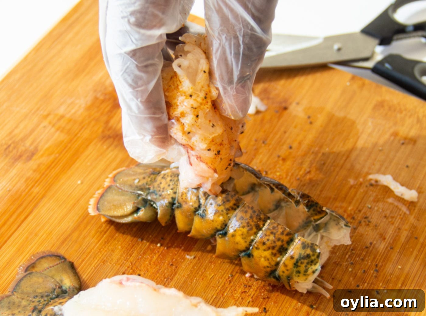 Folding lobster meat back over the tail shell after seasoning