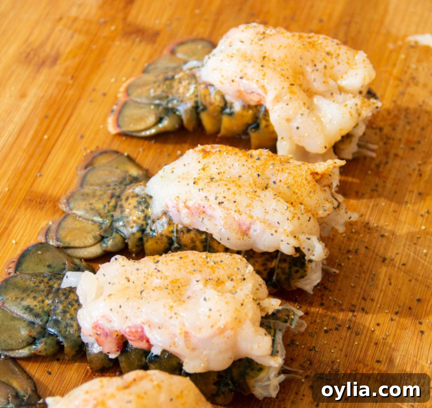 Fully seasoned and crowned lobster tail resting on a cutting board, ready for steaming
