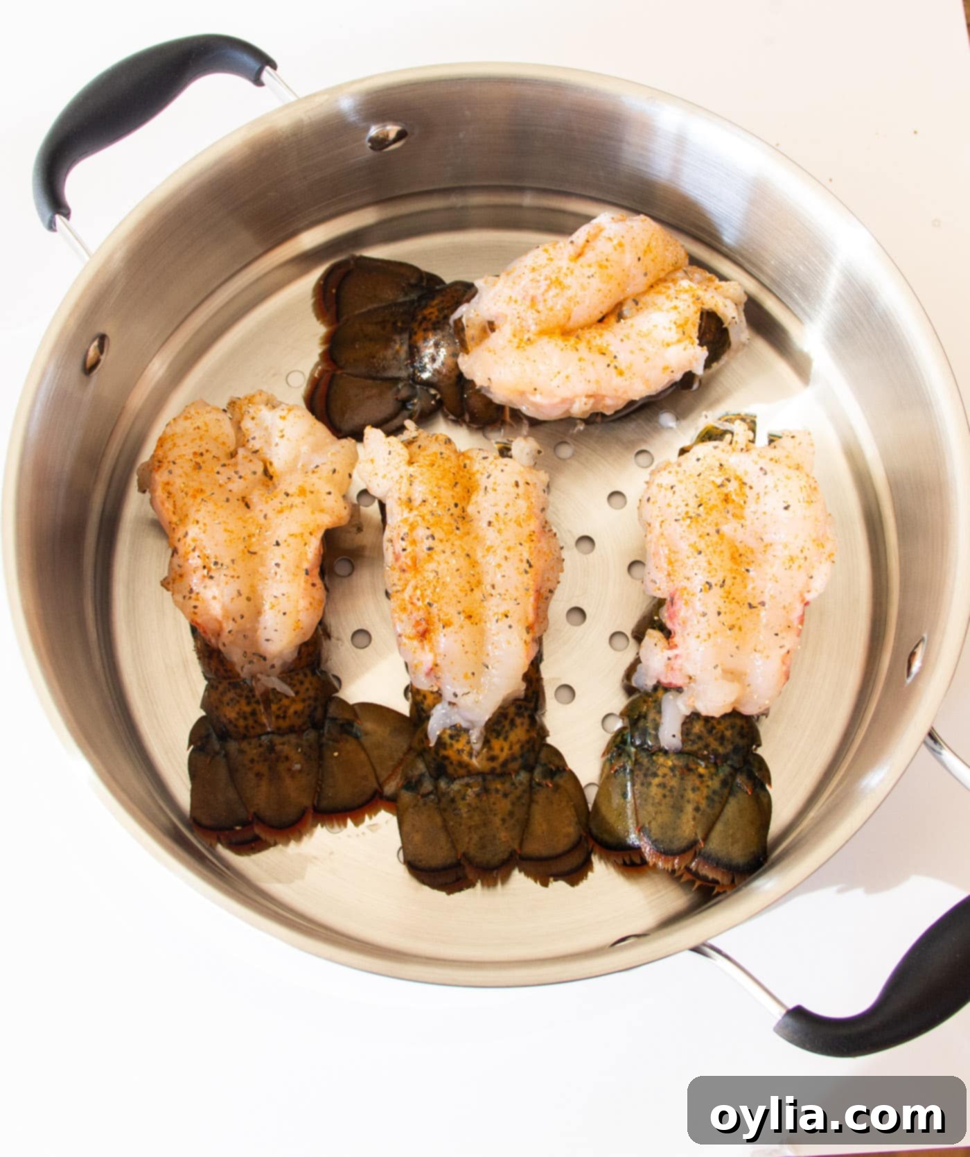 Crowned lobster tails placed in the steam pot for cooking