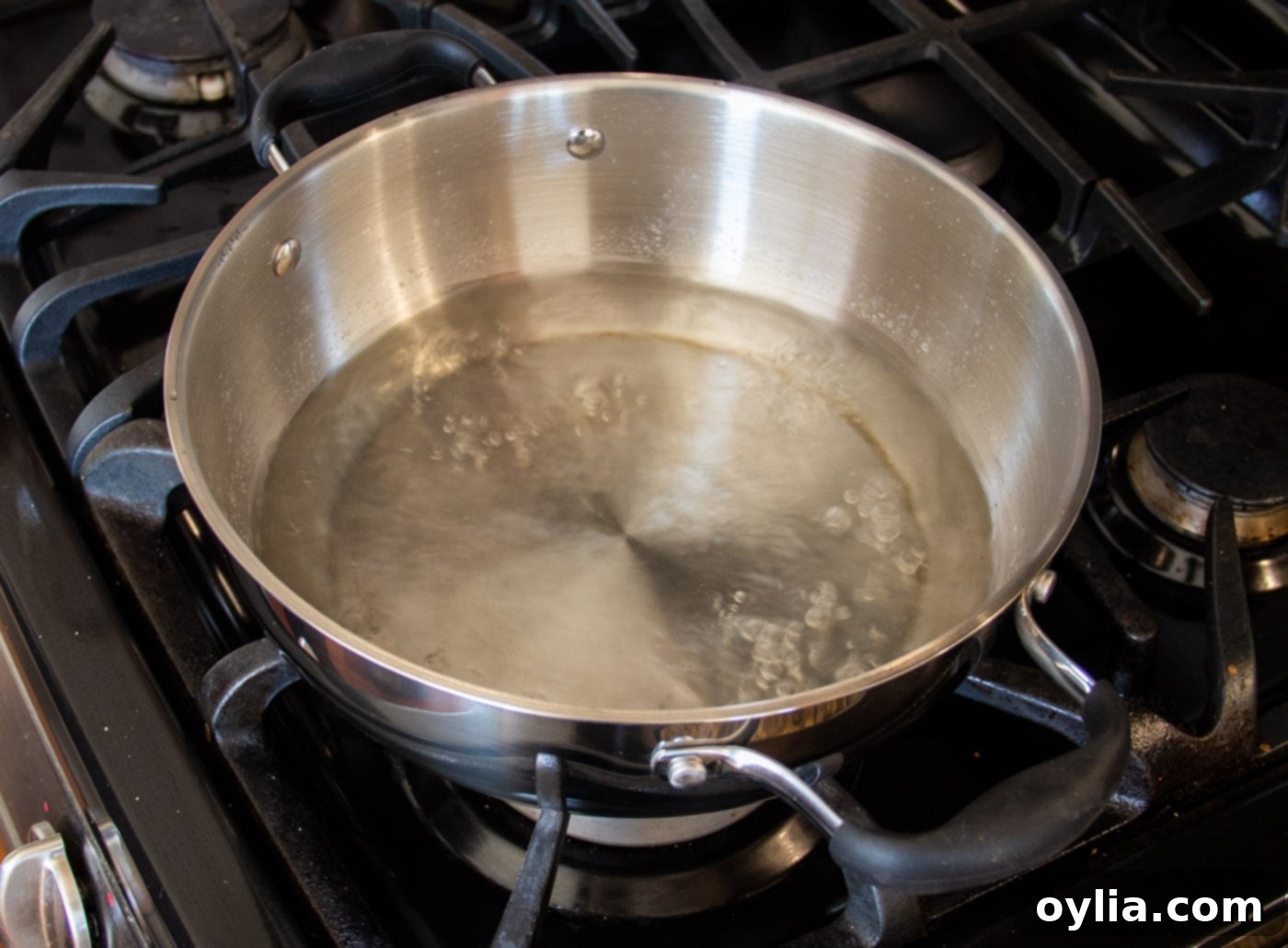 Water boiling in the bottom section of a steam pot, creating steam