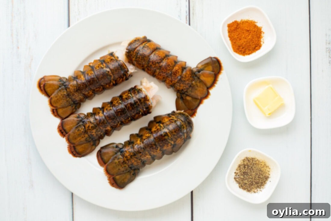 Tender Steamed Lobster Tail 4 Steamed Lobster Tail ingredients laid out on a cutting board, including lobster tails, butter, Old Bay, and pepper