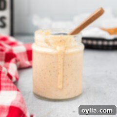 A small jar of creamy Alabama White Sauce, adorned with a white border, perfect for dipping
