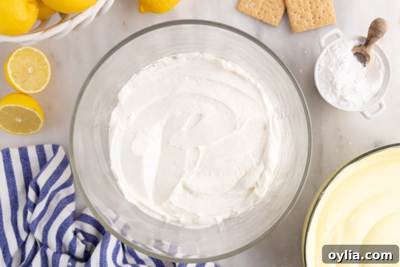 cream cheese mixture on top of graham cracker crumbs in trifle dish
