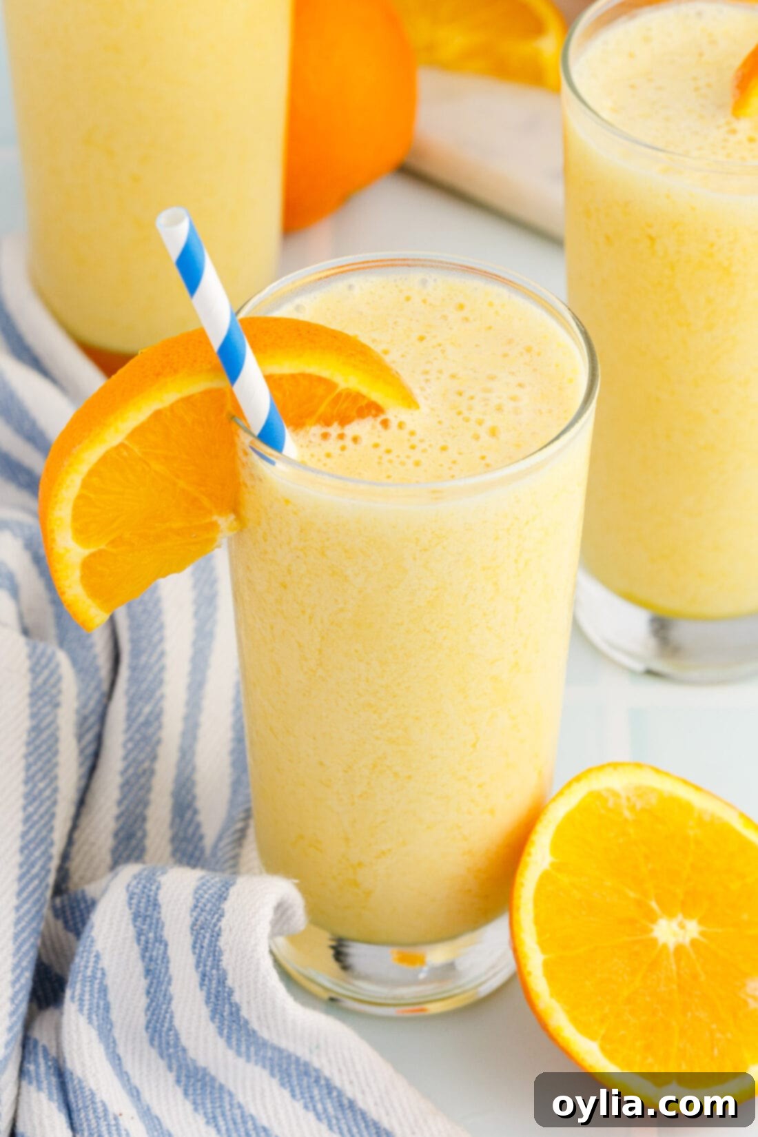 Orange Julius 7 glass of Orange Julius with an orange slice and straw