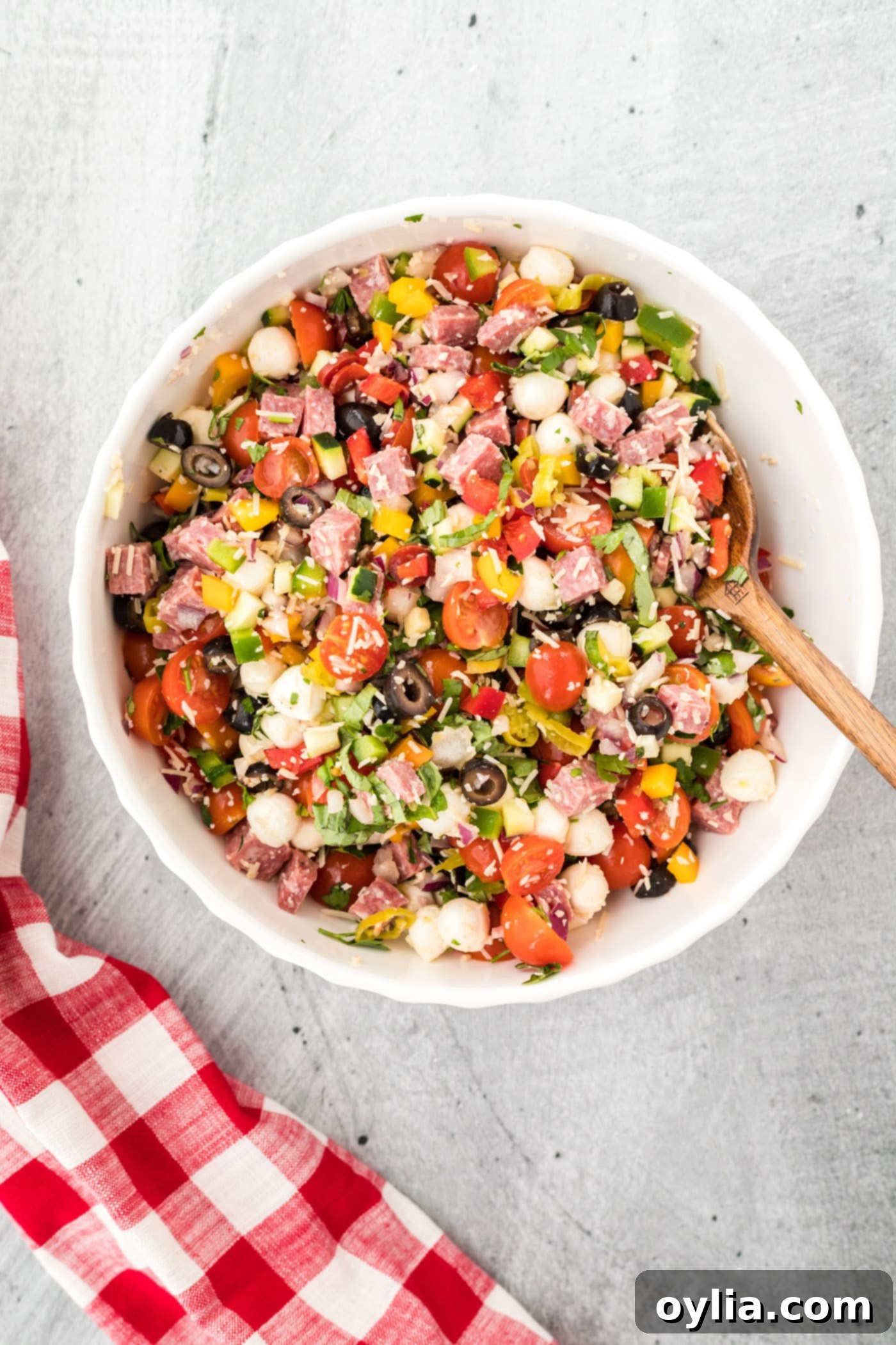 italian pasta salad veggies and meats mixed in a bowl