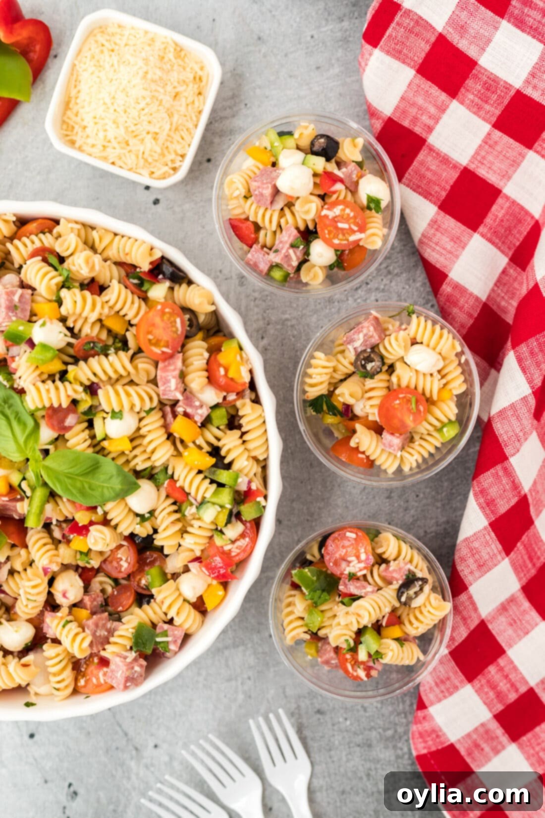 bowl of Italian Pasta Salad with three servings in small cups, showcasing vibrant colors