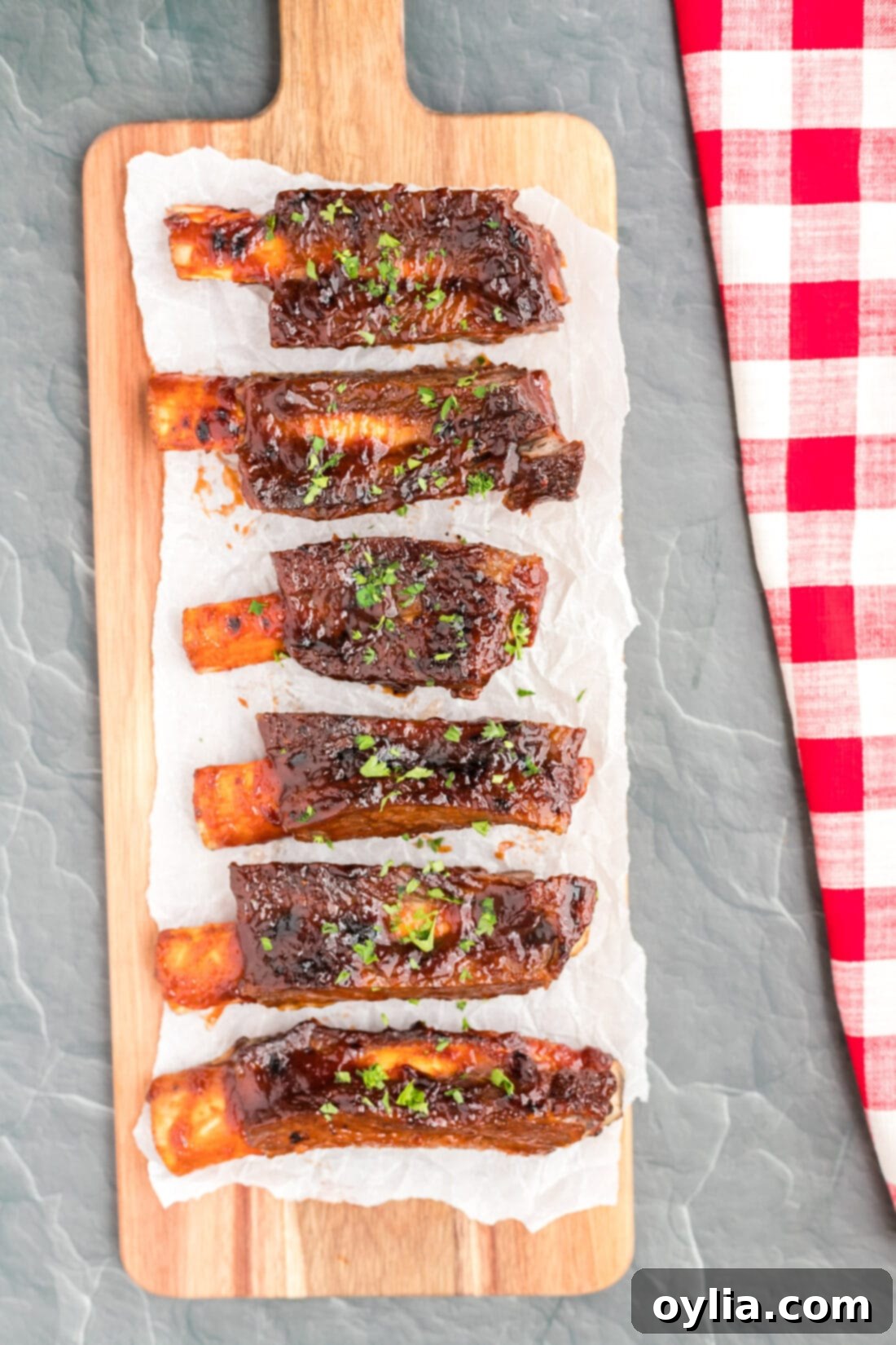 Tender Instant Pot Beef Ribs 2 Instant Pot Beef Ribs on a long cutting board, perfectly cooked and ready to serve.