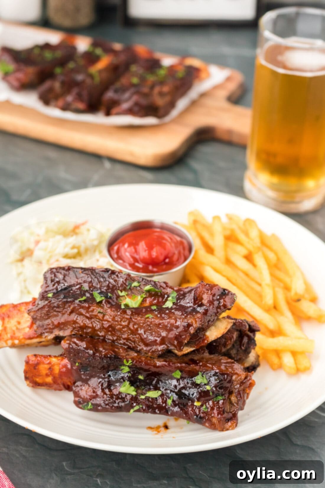 Tender Instant Pot Beef Ribs 3 A plate of delicious Instant Pot Beef Ribs served with a side of golden French fries, perfectly coated in barbecue sauce.