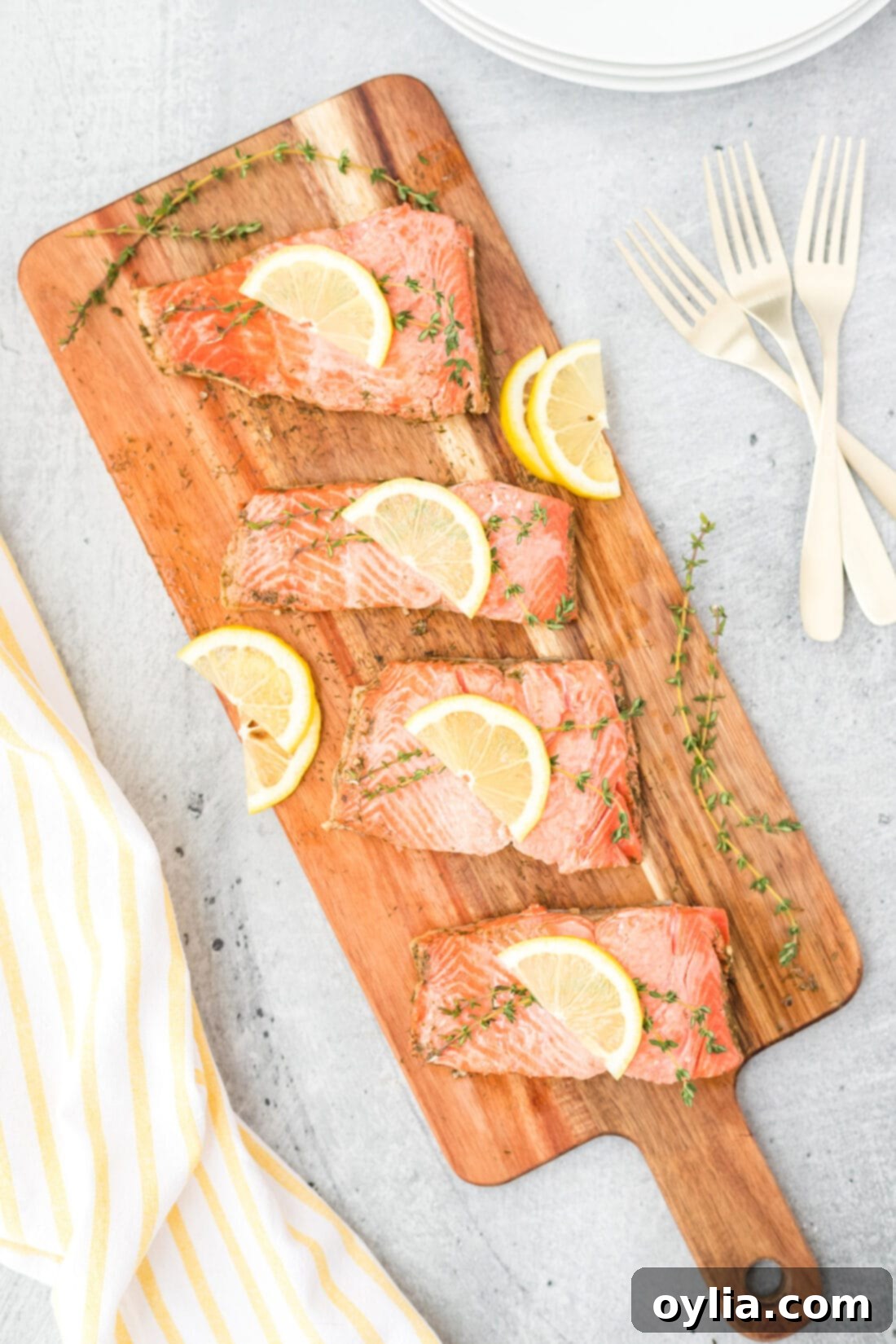 Silky Poached Salmon 2 Poached Salmon on a cutting board, garnished with fresh herbs