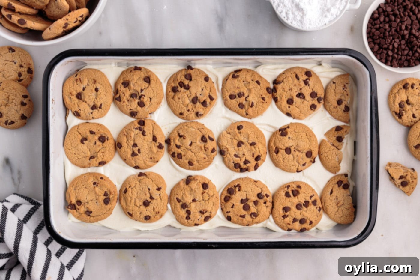 Visually appealing layers of chocolate chip cookies and creamy filling neatly arranged in a dish, showing the progression of the icebox cake