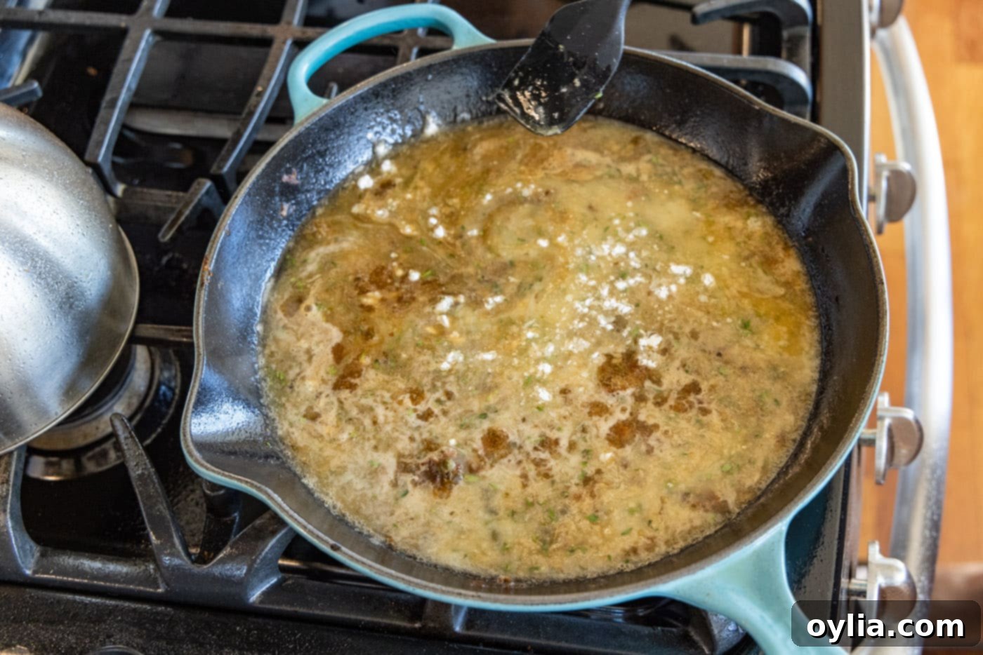 adding cornstarch slurry to veal piccata sauce in a skillet to thicken