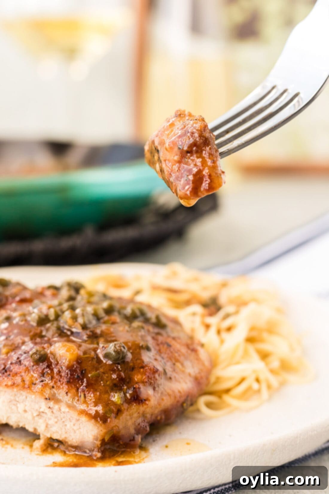 fork with a bite of Veal Piccata on it, ready to eat