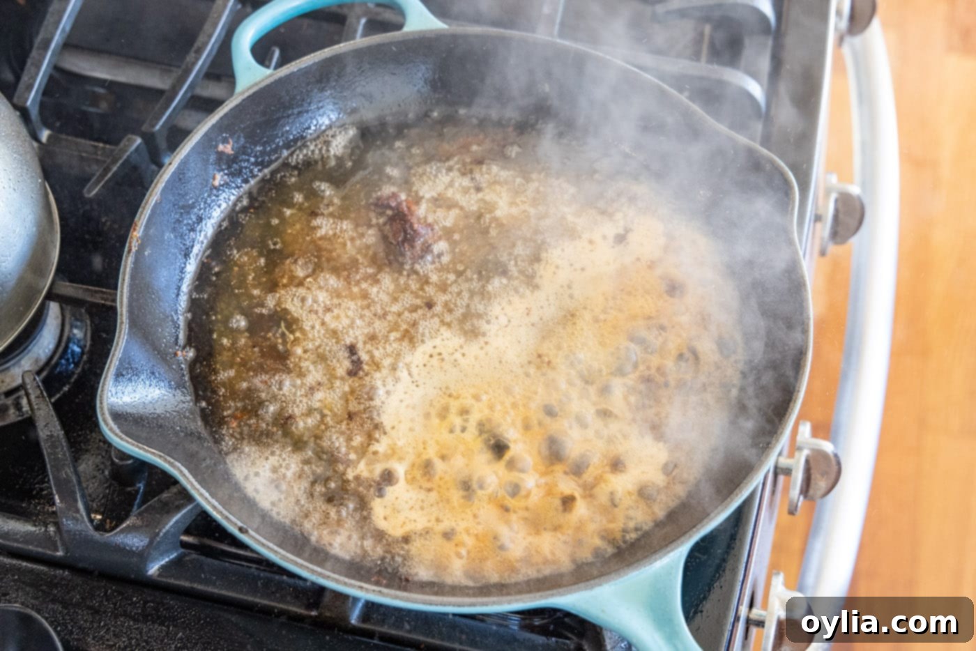 veal piccata sauce simmering in a skillet