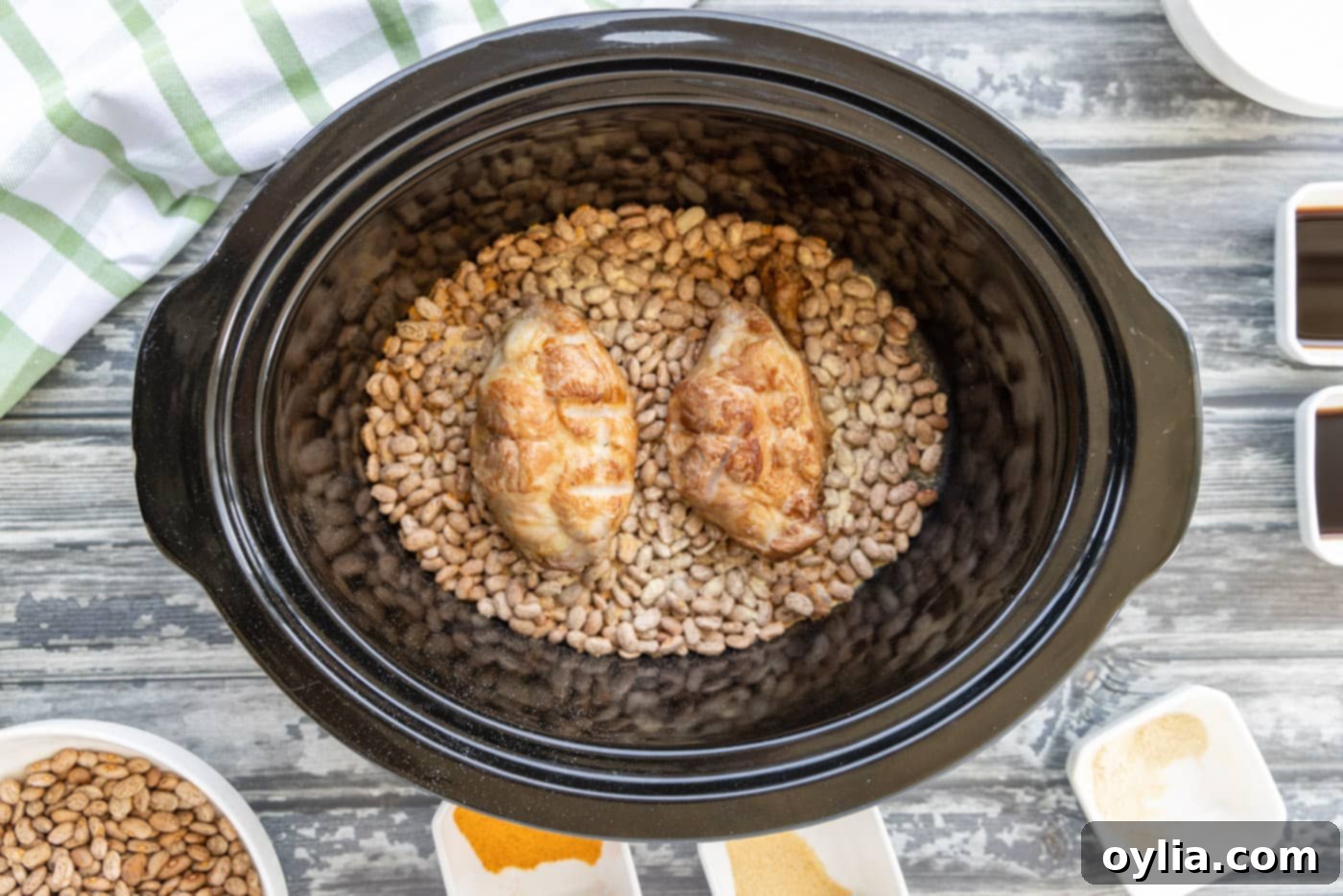 Smoked turkey tails placed on seasoned pinto beans in a crockpot