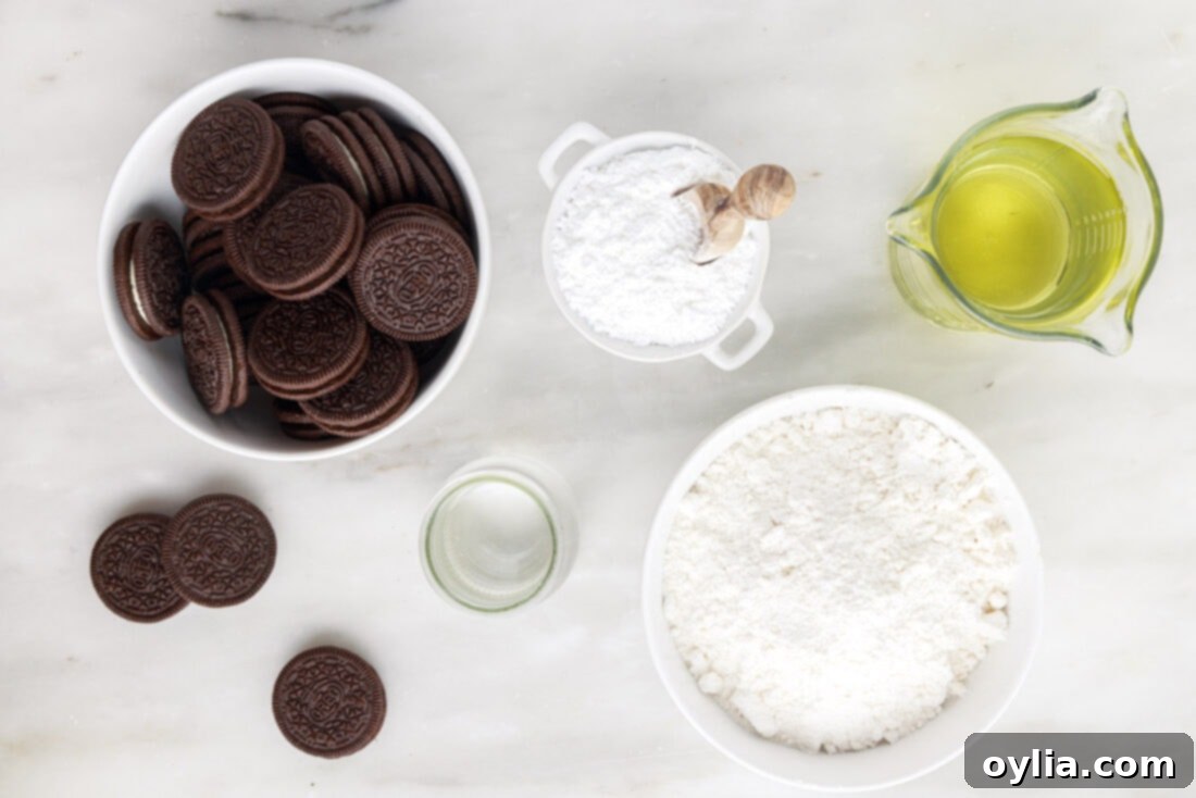 All the ingredients laid out for making Fried Oreos: a package of Oreos, pancake mix, water, vegetable oil, and powdered sugar.
