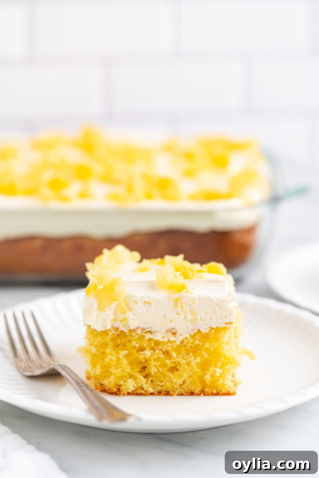 Close-up of a delicious piece of Pineapple Sunshine Cake with a light, airy frosting