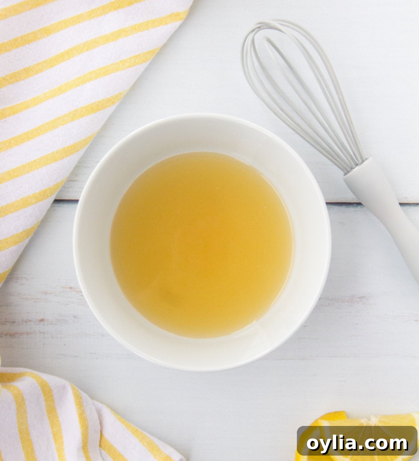 A bowl containing a mixture of honey, salt, brown sugar, and lemon juice, ready to be whisked for the couscous dressing.