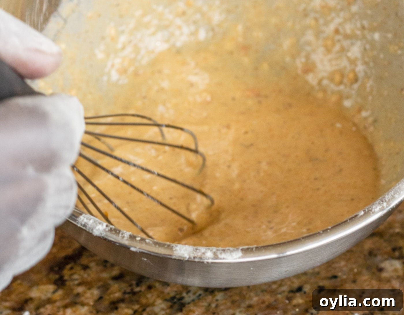 A bowl containing the cornmeal and egg mixture, ready for shrimp dredging.