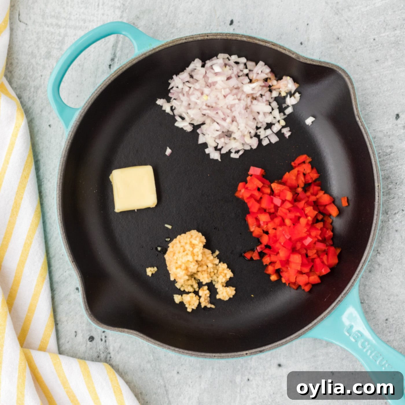 Red bell pepper, shallots, and garlic sizzling with butter in a skillet