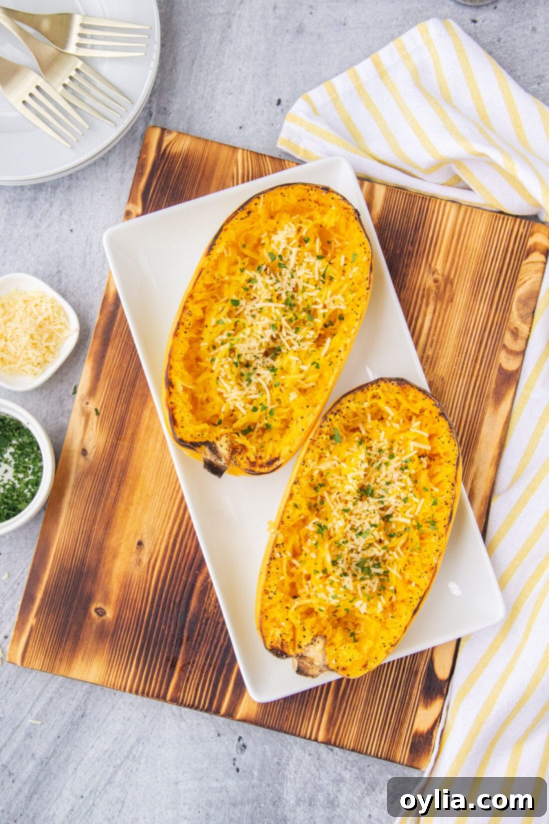 Golden Spaghetti Squash Bake 2 Golden-brown baked spaghetti squash halves on a rustic cutting board, ready to be shredded into pasta-like strands.