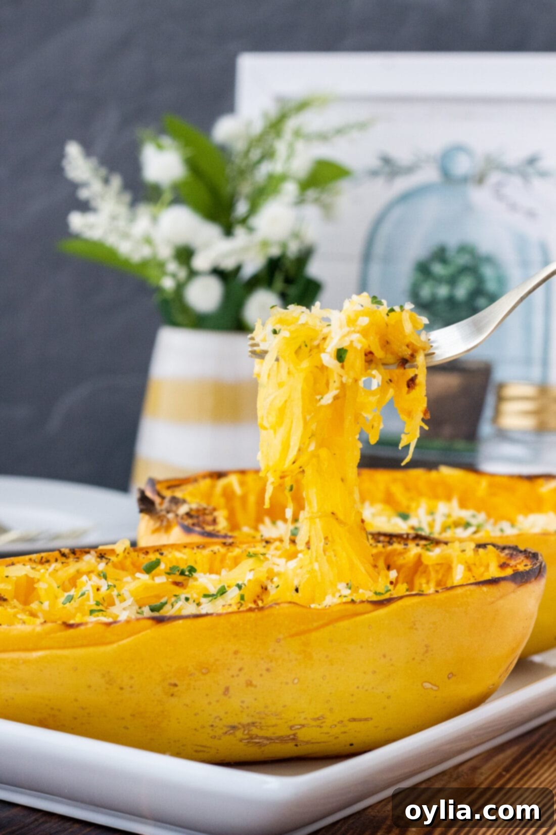 Golden Spaghetti Squash Bake 3 A fork lifts tender, golden strands of baked spaghetti squash from its shell, showcasing its pasta-like texture.